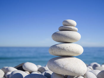 Stack of stones on beach against sky