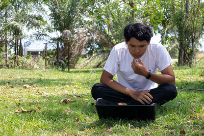 Young man sitting on field