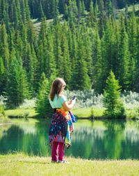 Rear view full length of girl photographing lake