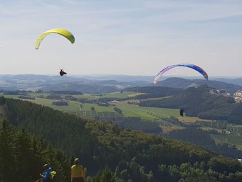 Person paragliding against sky