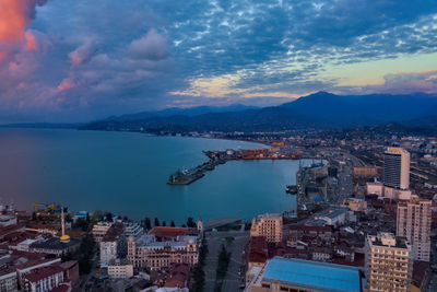 High angle view of city by sea against sky