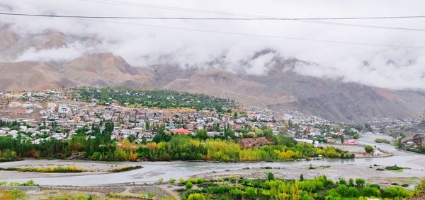 Aerial view of townscape and mountains against sky