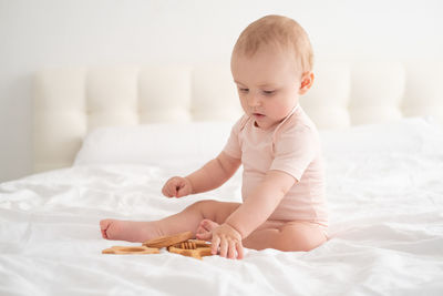 Cute baby boy lying on bed at home