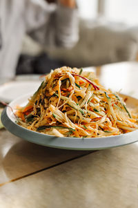 Asian chinese salad of cabbage, cucumber, carrot, noodles and sesame seeds. serving asian dishes