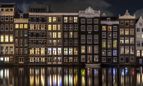 Reflection of buildings on river at night