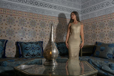 Woman standing on tiled floor against wall