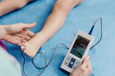 Doctor with oximeter examining little patient