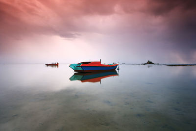 Boats moored at sea against sky