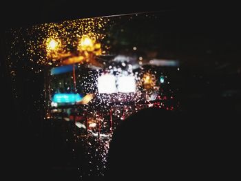 Rear view of wet glass window at night