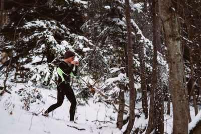 Man punching snowy tree