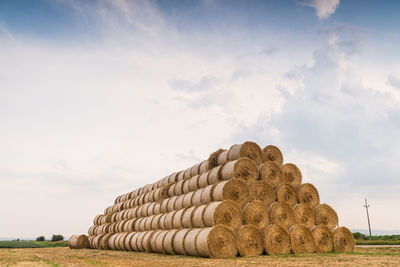 Hay bales on field against sky