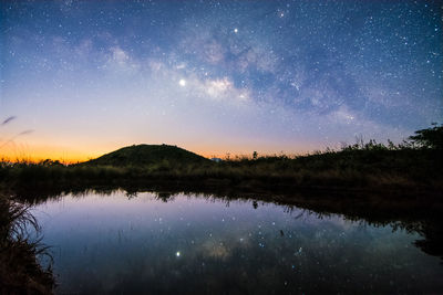 Scenic view of lake against sky at night