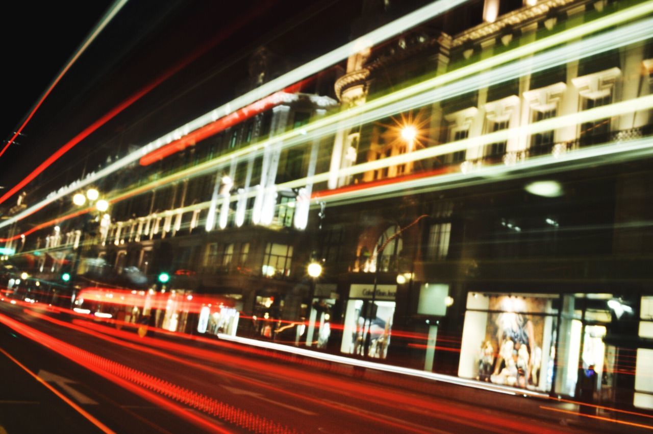 illuminated, transportation, night, architecture, built structure, blurred motion, motion, long exposure, speed, red, light trail, lighting equipment, bridge - man made structure, mode of transport, city, building exterior, no people, rail transportation, outdoors, public transportation, connection, sky