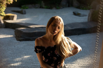 Portrait of young woman while standing outdoors