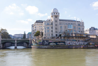 Bridge over river against buildings in city