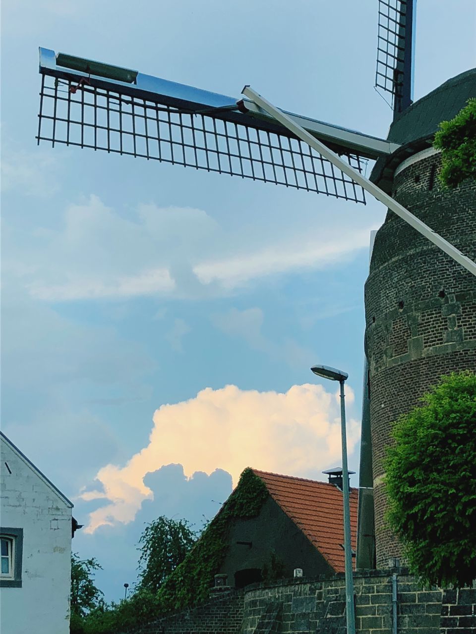 LOW ANGLE VIEW OF WINDMILL AND BUILDING AGAINST SKY