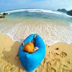 Woman relaxing in bean bag at beach