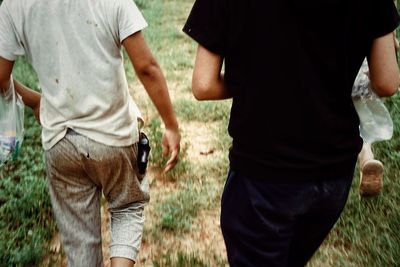 Midsection of people walking on field