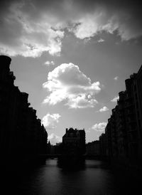 Buildings in city against cloudy sky