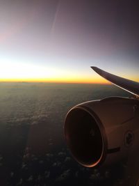 Airplane flying against sky during sunset