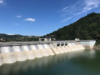 View of dam by river against sky