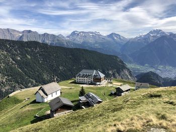 Scenic view of houses and mountains against sky