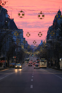 Cars on city street during sunset