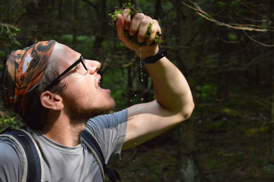 Man drinking water from moss