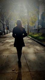 Full length rear view of woman walking in city