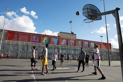 People playing soccer against sky