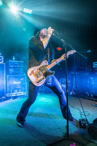 Man playing guitar at illuminated music concert