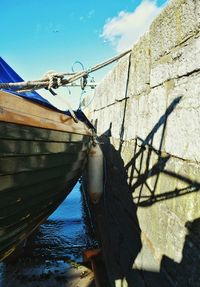 Low angle view of boat moored on shore against sky