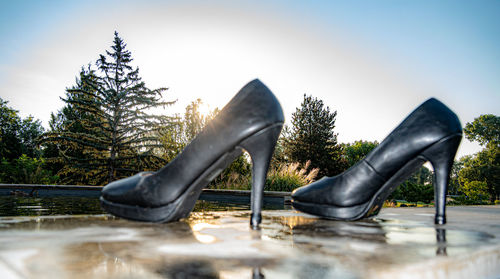 Low section of person wearing shoes against clear sky