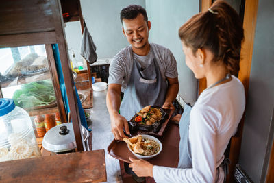 Portrait of young woman preparing food at home