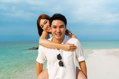 Portrait of young couple standing on beach