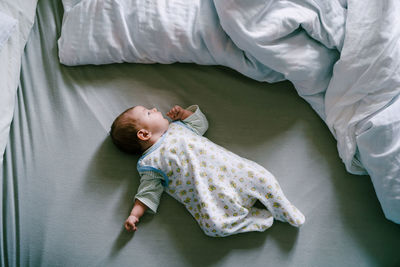 High angle view of baby lying on bed