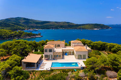 Houses by sea against sky