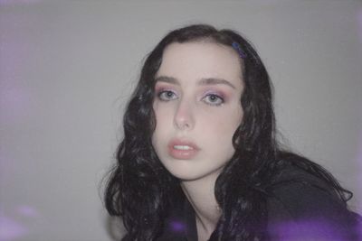 Portrait of beautiful woman against purple background