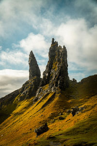 Old man of storr rock formations with golden light and dramatic sky on isle of skye scotland.