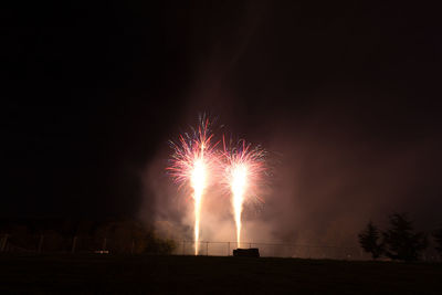 Low angle view of firework display at night