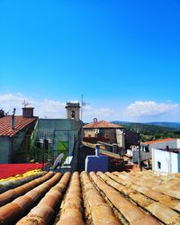 Buildings in city against blue sky