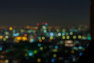 Defocused image of illuminated lights in city at night