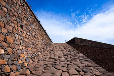 Low angle view of stone wall against sky