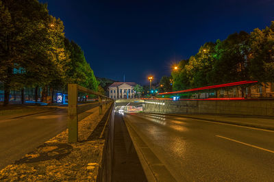 Light trails on road against sky at night