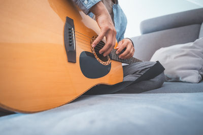 Midsection of man playing guitar