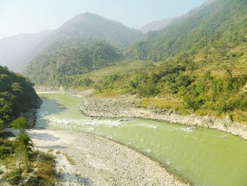 Scenic view of stream by landscape against sky