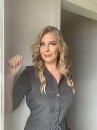 Portrait of a smiling young woman standing against wall