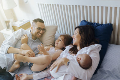 Couple sitting on bed at home