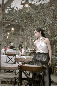 Side view of young woman sitting at outdoor cafe