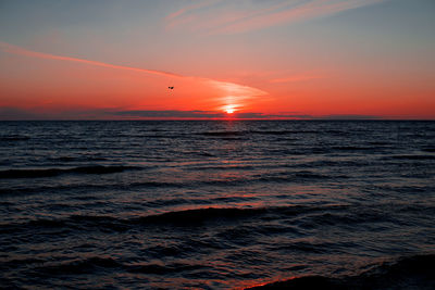 Scenic view of sea against cloudy sky during sunset